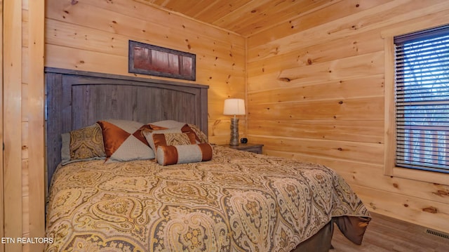 bedroom featuring wooden walls, wooden ceiling, and hardwood / wood-style flooring