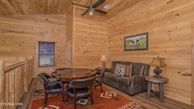 living room featuring wood walls, lofted ceiling, ceiling fan, wood-type flooring, and wood ceiling