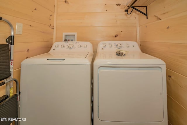 washroom with independent washer and dryer and wood walls