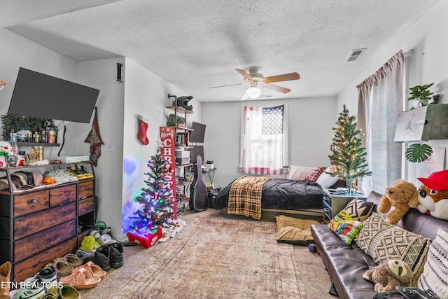 carpeted bedroom with a textured ceiling and ceiling fan