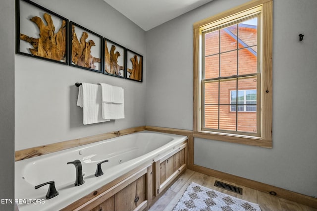 bathroom with a washtub and hardwood / wood-style flooring