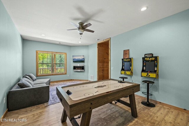 rec room with light hardwood / wood-style floors and ceiling fan