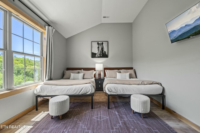 bedroom featuring wood-type flooring and vaulted ceiling