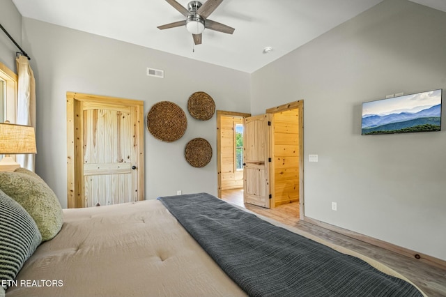 bedroom featuring ceiling fan, hardwood / wood-style floors, and lofted ceiling