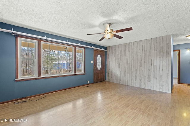 interior space with ceiling fan, light hardwood / wood-style flooring, and a textured ceiling