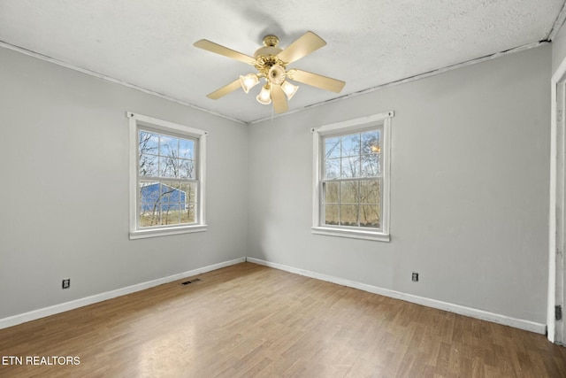 empty room featuring ceiling fan, a textured ceiling, and light hardwood / wood-style flooring