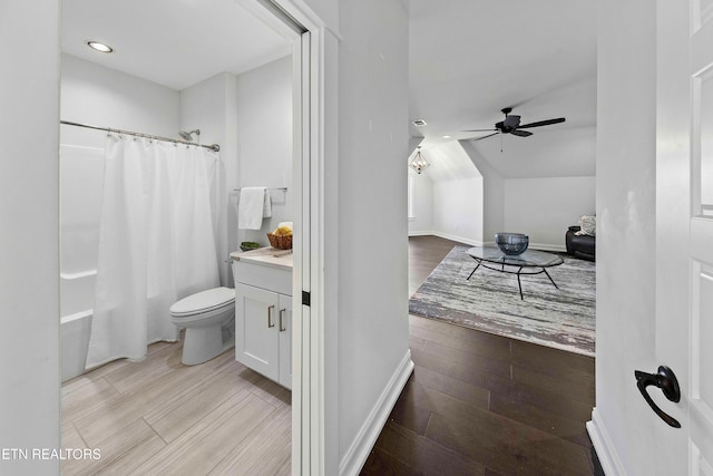 full bathroom featuring hardwood / wood-style floors, shower / bath combo, vanity, ceiling fan, and toilet