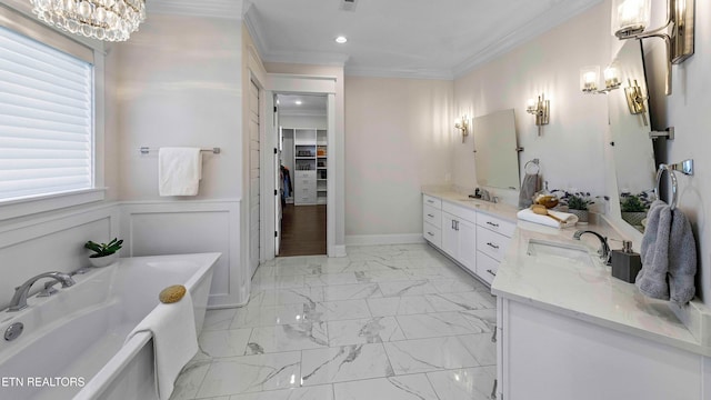 bathroom featuring a bath, vanity, an inviting chandelier, and crown molding