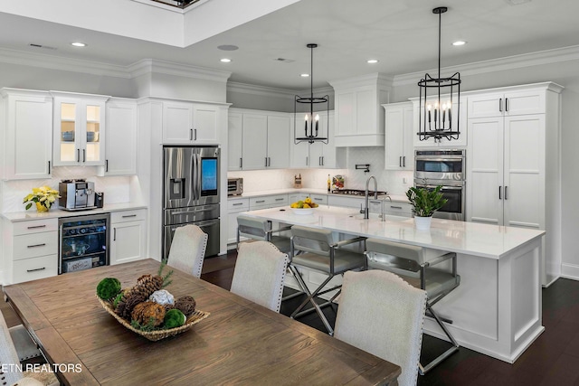 kitchen with white cabinets, hanging light fixtures, dark hardwood / wood-style floors, and appliances with stainless steel finishes