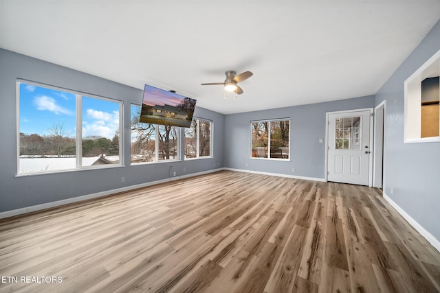 unfurnished living room featuring ceiling fan and light wood-type flooring