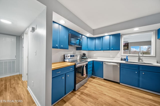 kitchen with light hardwood / wood-style floors, sink, blue cabinets, and stainless steel appliances