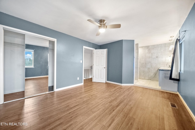 unfurnished bedroom featuring light hardwood / wood-style flooring, a closet, and ceiling fan