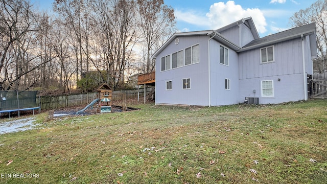 exterior space featuring a playground, a trampoline, a yard, and central air condition unit