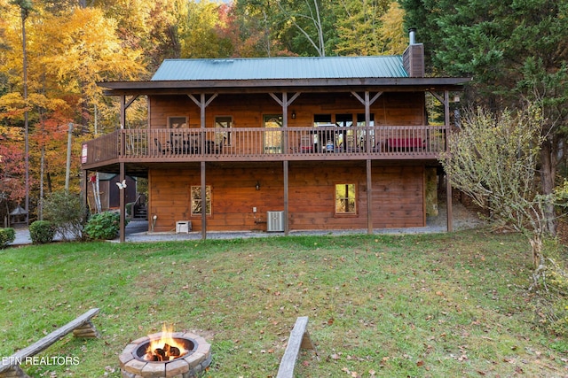 rear view of property with a yard, central AC, an outdoor fire pit, and a wooden deck