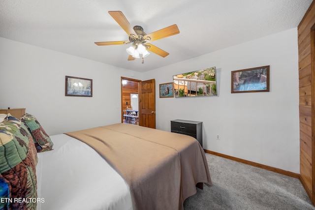 carpeted bedroom with ceiling fan and a textured ceiling