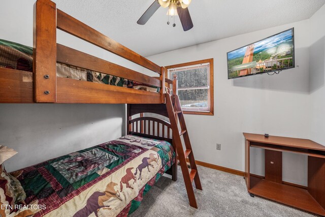 carpeted bedroom featuring ceiling fan and a textured ceiling