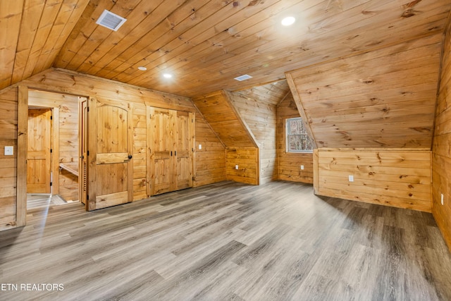 additional living space featuring hardwood / wood-style flooring, vaulted ceiling, wooden walls, and wood ceiling