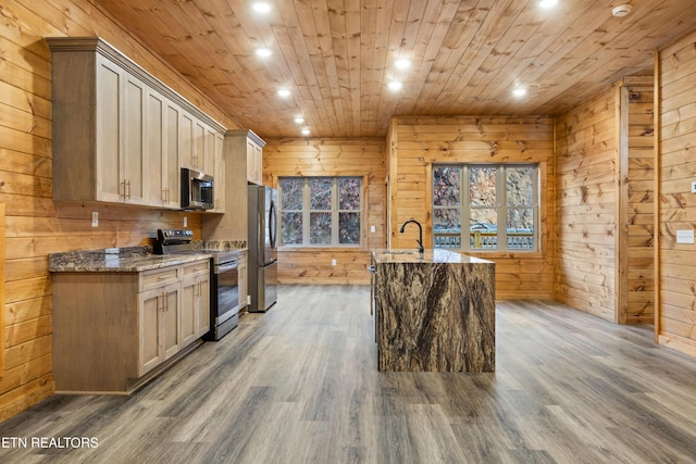 kitchen featuring light brown cabinets, wood walls, dark wood-type flooring, and appliances with stainless steel finishes