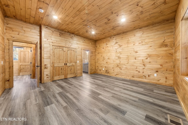 unfurnished bedroom featuring wood walls, wood-type flooring, and wooden ceiling