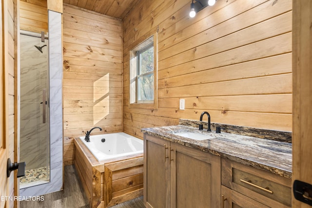 bathroom with wooden ceiling, hardwood / wood-style floors, shower with separate bathtub, wooden walls, and vanity