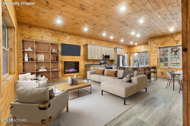 living area featuring wood walls, recessed lighting, light wood-style flooring, and wooden ceiling
