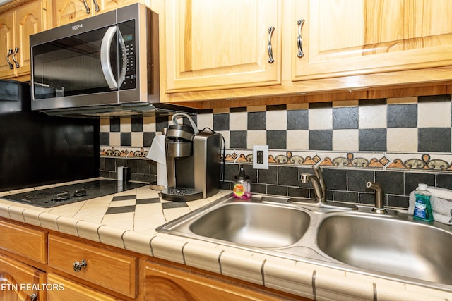 kitchen with tile counters, sink, and tasteful backsplash