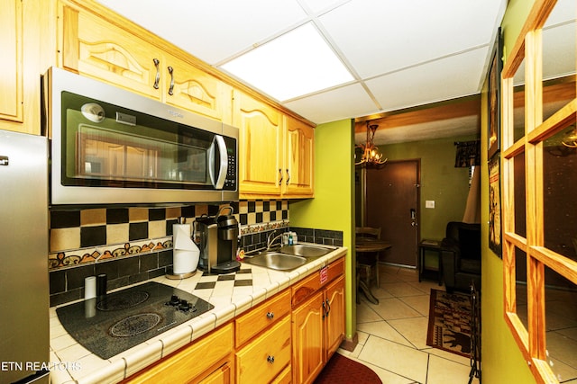 kitchen with tile counters, sink, stainless steel appliances, backsplash, and light tile patterned floors