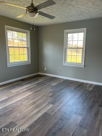 empty room with ceiling fan, plenty of natural light, wood-type flooring, and a textured ceiling