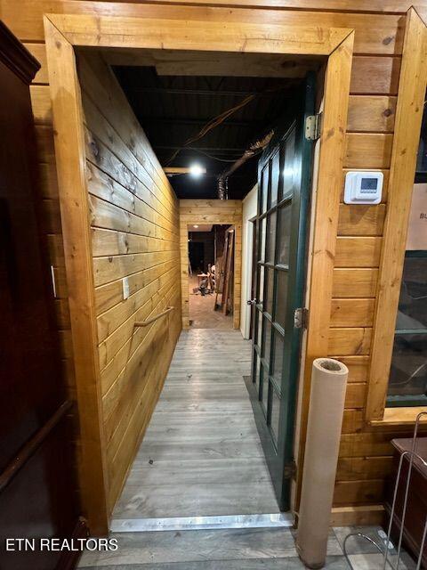 hall with hardwood / wood-style flooring and wooden walls