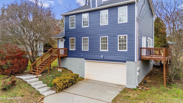 view of front facade with a garage and a wooden deck