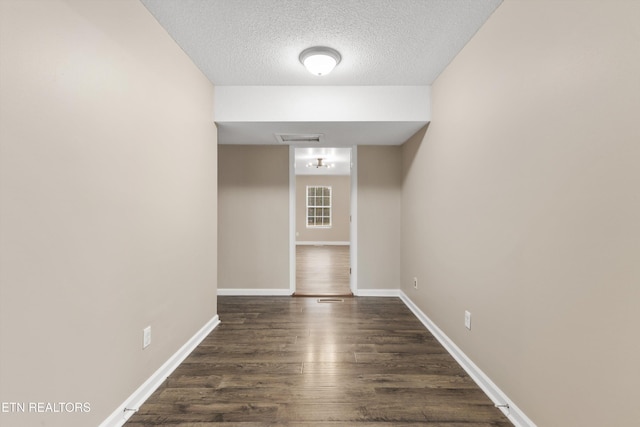 interior space featuring dark hardwood / wood-style flooring and a textured ceiling