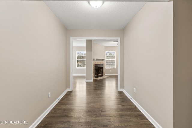 hallway with dark hardwood / wood-style flooring and a textured ceiling