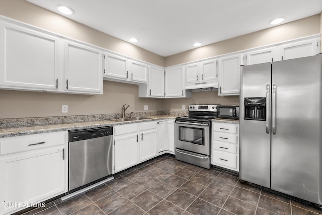 kitchen with light stone counters, white cabinetry, sink, and appliances with stainless steel finishes