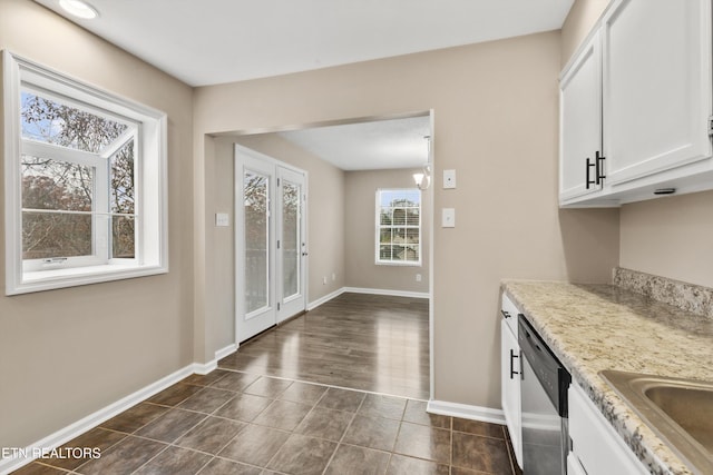 kitchen featuring light stone countertops, stainless steel dishwasher, dark wood-type flooring, a chandelier, and white cabinetry