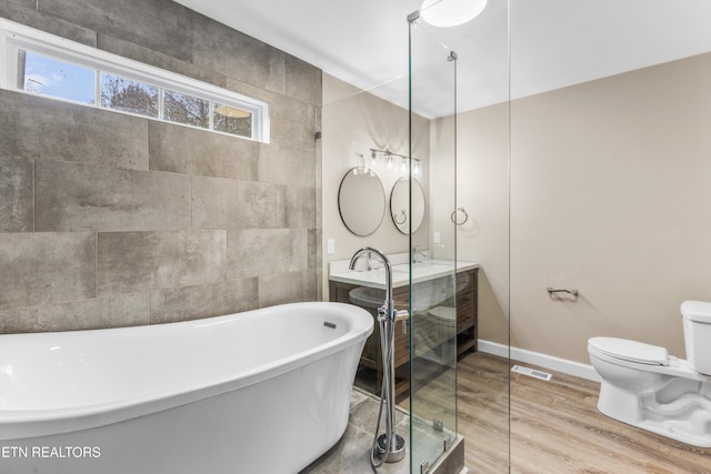 bathroom with hardwood / wood-style flooring, a washtub, and toilet