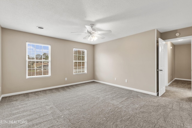 carpeted empty room featuring ceiling fan and a textured ceiling