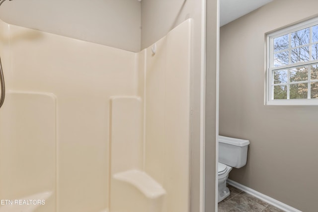 bathroom with a shower, tile patterned flooring, and toilet