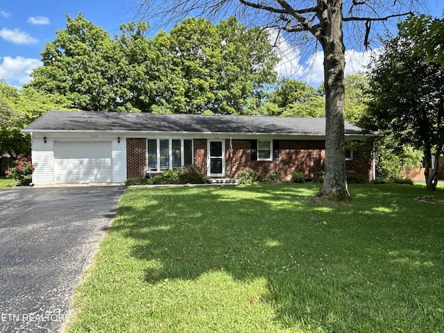 ranch-style house with a garage and a front lawn