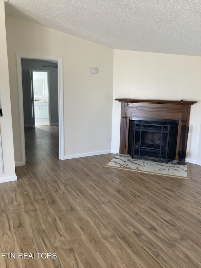 unfurnished living room with dark hardwood / wood-style flooring and a textured ceiling