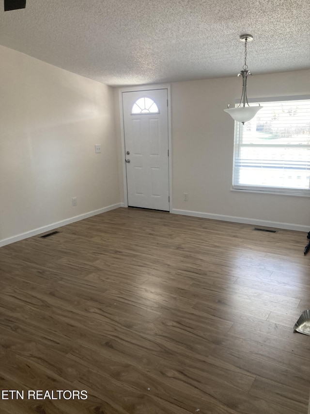 foyer with a textured ceiling and dark wood-type flooring