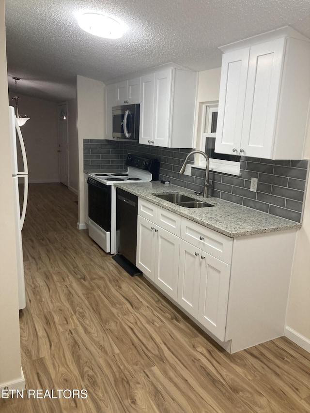 kitchen featuring decorative backsplash, light hardwood / wood-style flooring, white cabinetry, and sink