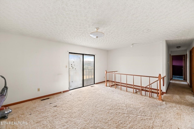 carpeted empty room featuring a textured ceiling