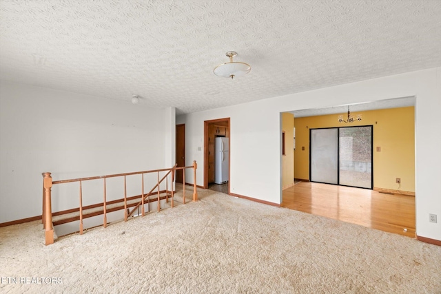 unfurnished room with hardwood / wood-style floors and a textured ceiling