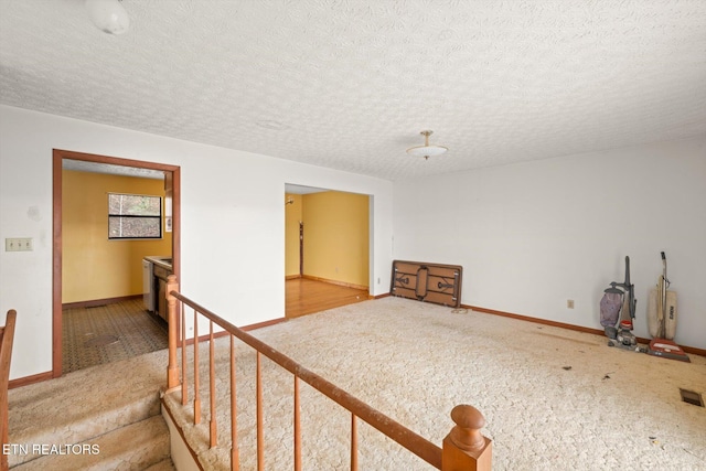 carpeted spare room featuring a textured ceiling