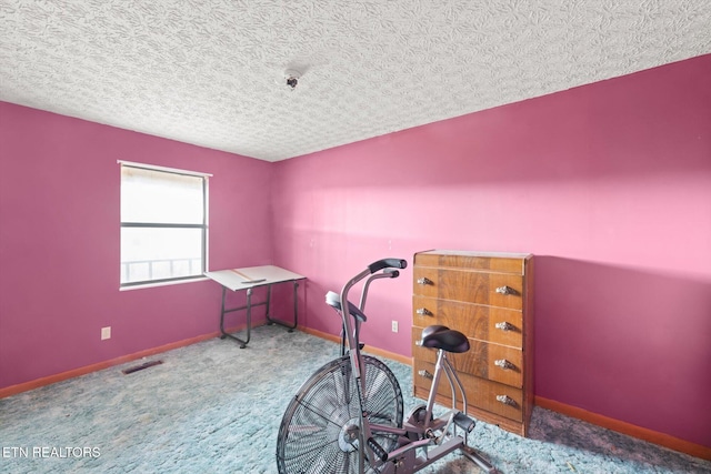 exercise area with carpet flooring and a textured ceiling