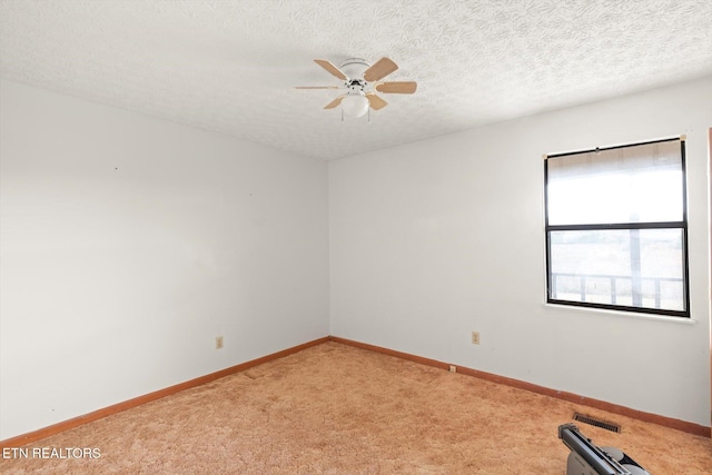 carpeted empty room featuring ceiling fan and a textured ceiling