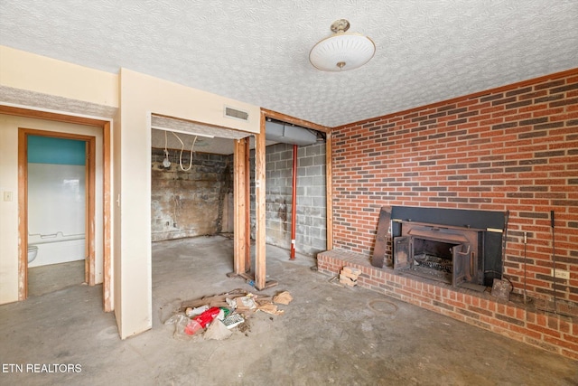 unfurnished living room featuring a textured ceiling and concrete floors