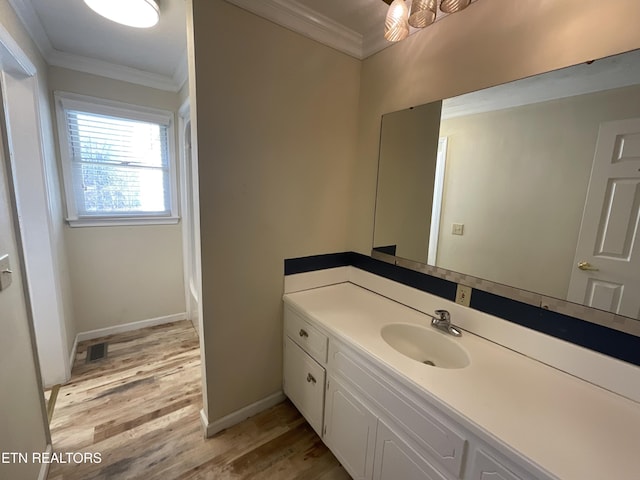 bathroom with vanity, ornamental molding, and hardwood / wood-style flooring