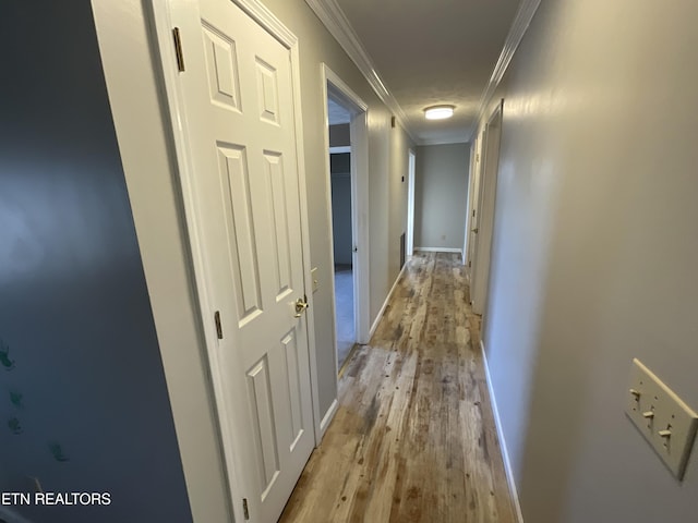 hall with light hardwood / wood-style flooring and crown molding