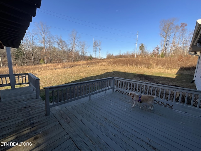 wooden deck featuring a lawn